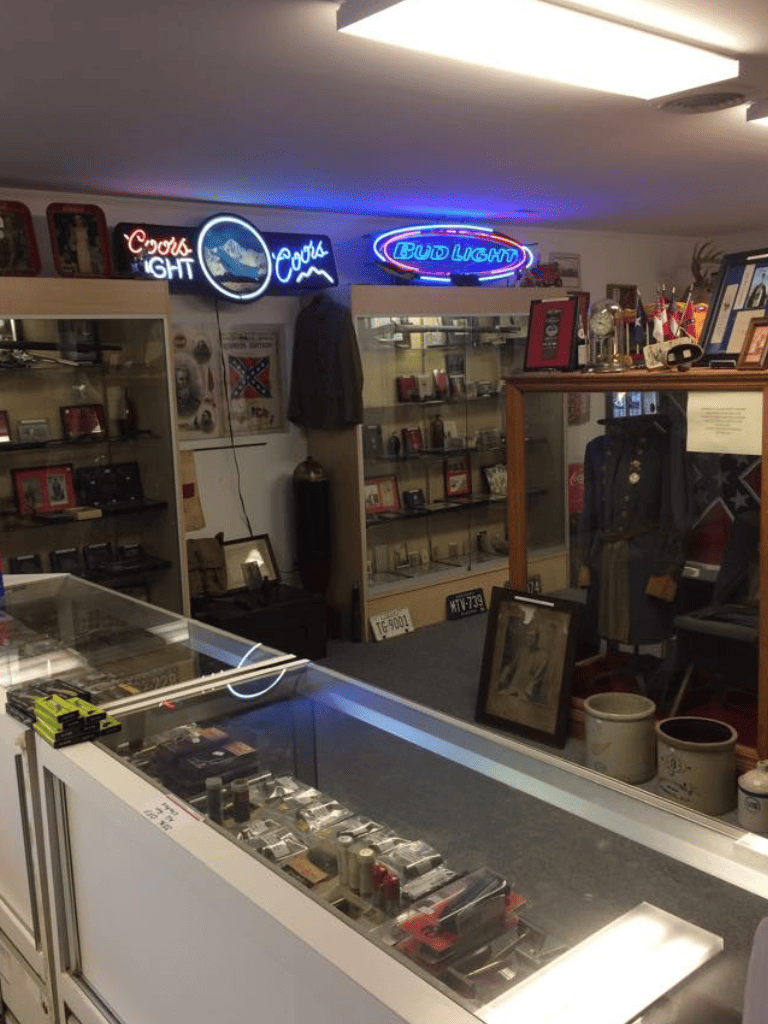 Neon signs and vintage collectibles in antique store, showcasing QuestForDirections memorabilia and unique decor.