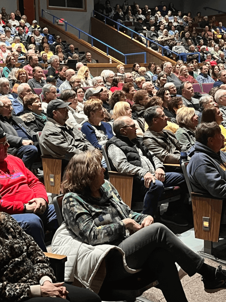 Audience seated attentively at a public event or seminar.