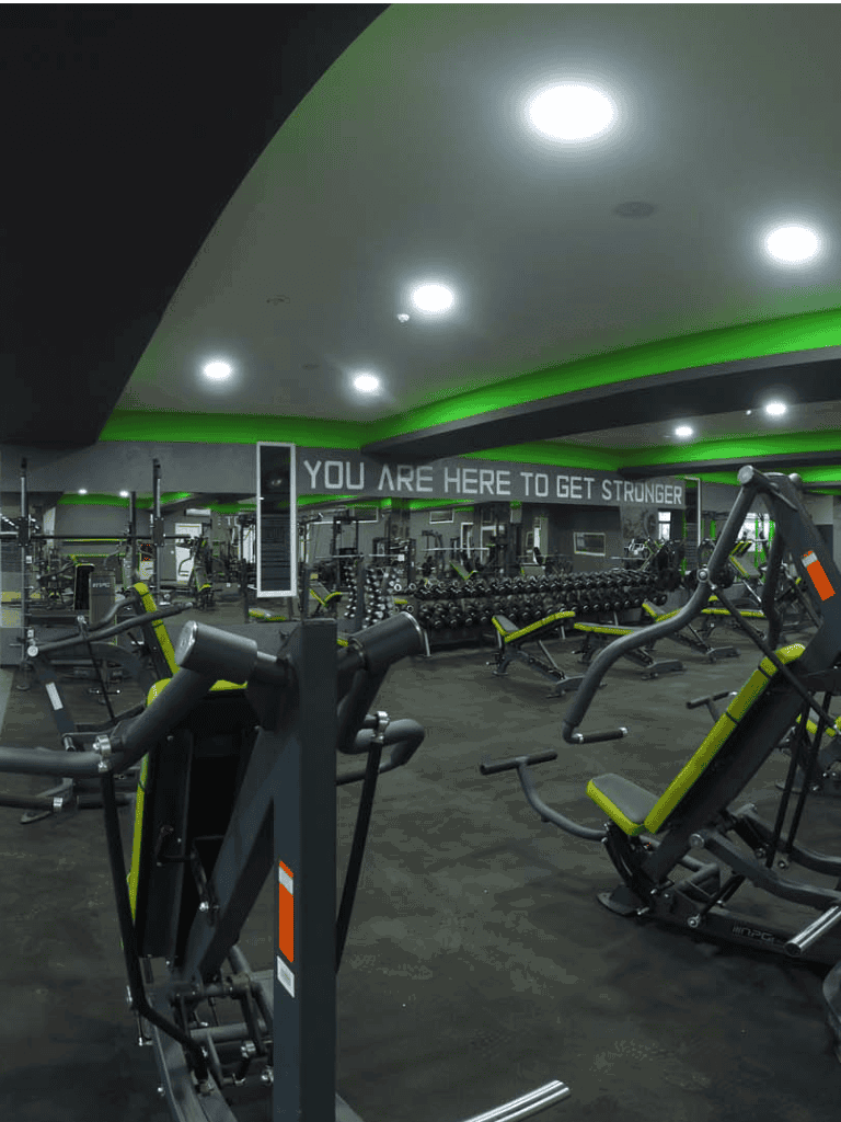 Modern gym interior with advanced workout equipment, motivational signage, and energy-efficient lighting, perfect for fitness enthusiasts.
