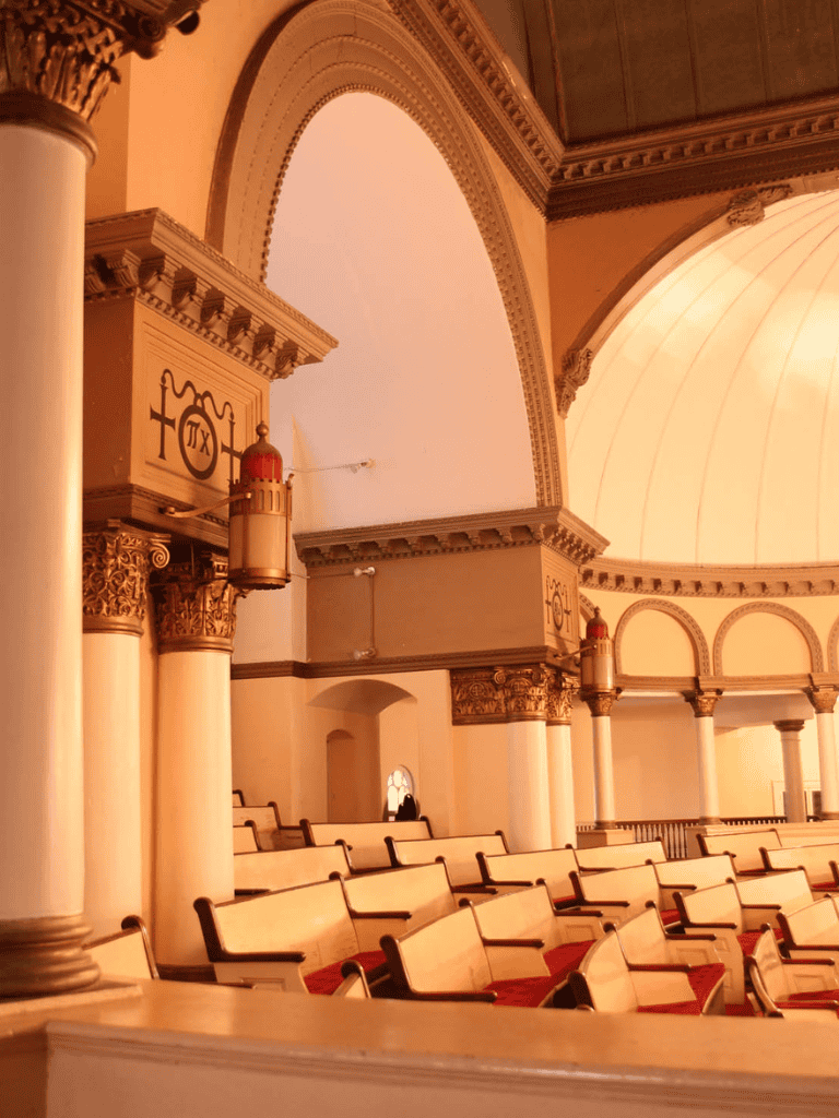 Spiritual event at Christian church with pews, arches, and grand interior architecture.