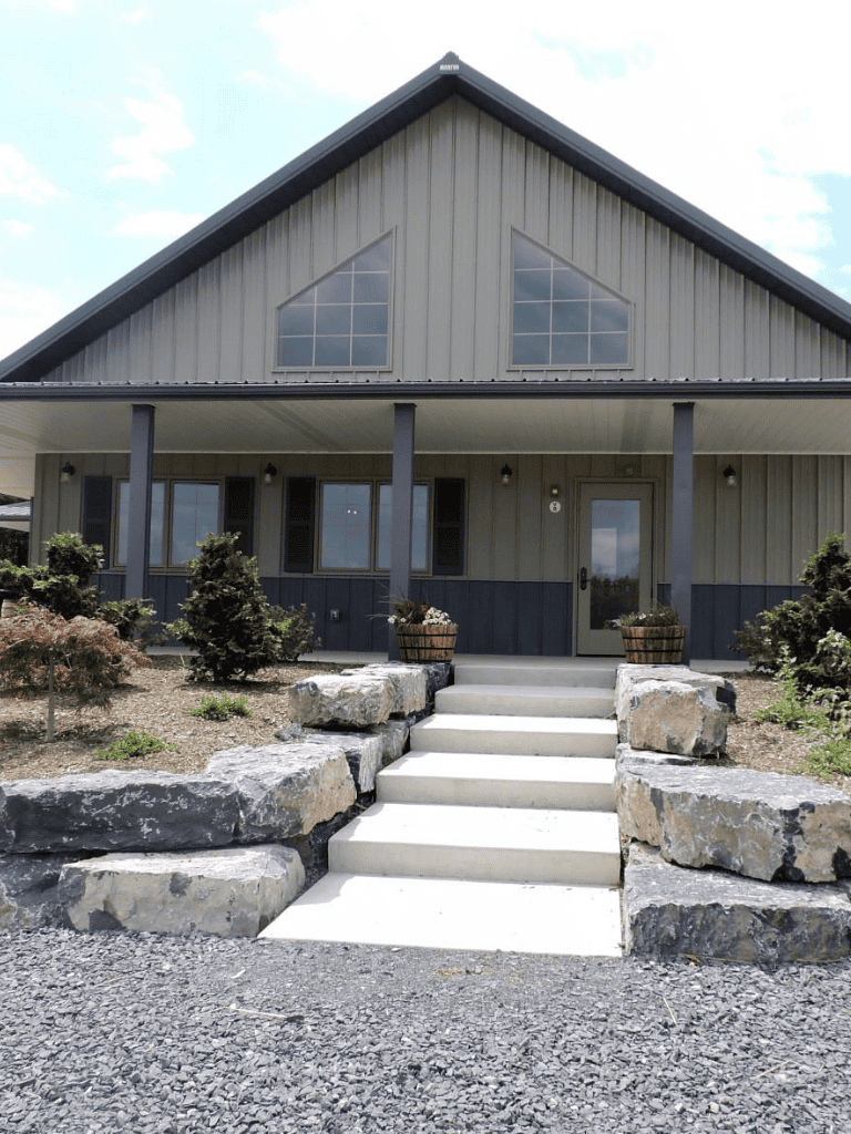 Modern farmhouse with stone steps and landscaped yard, perfect for outdoor living and relaxation.