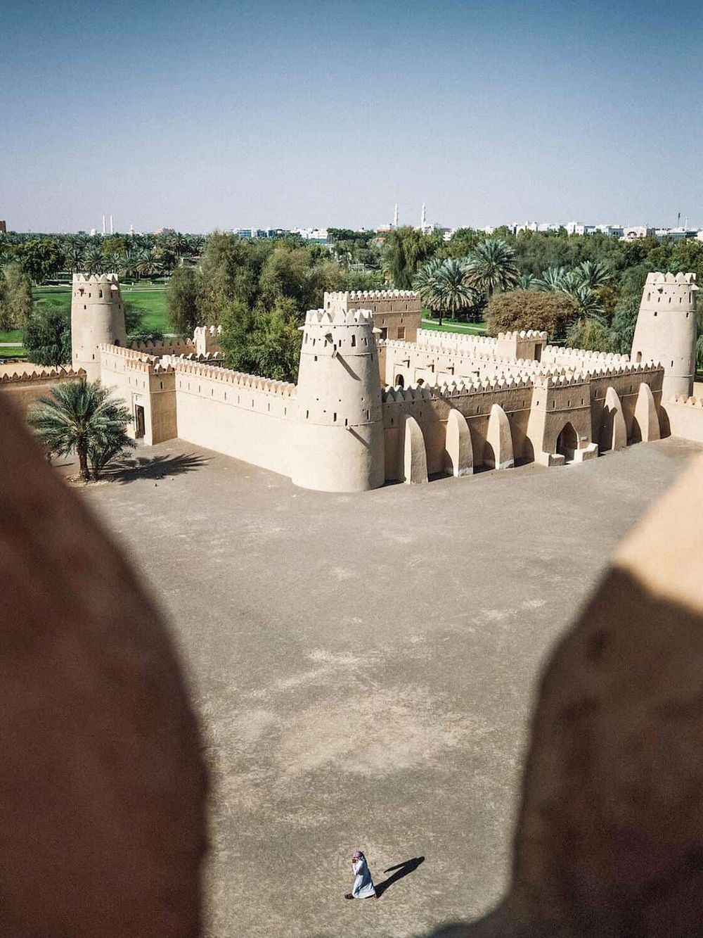 Majestic Middle Eastern fortress with lush greenery and traditional architecture, ideal for cultural tourism.