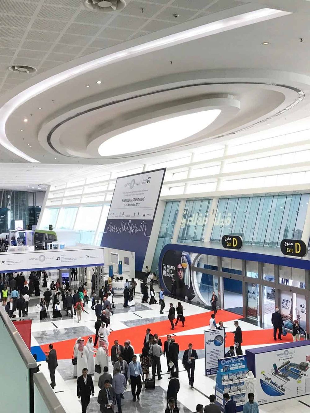 Bright airport terminal with travelers and security area, modern design, large digital screens, and clear signage.