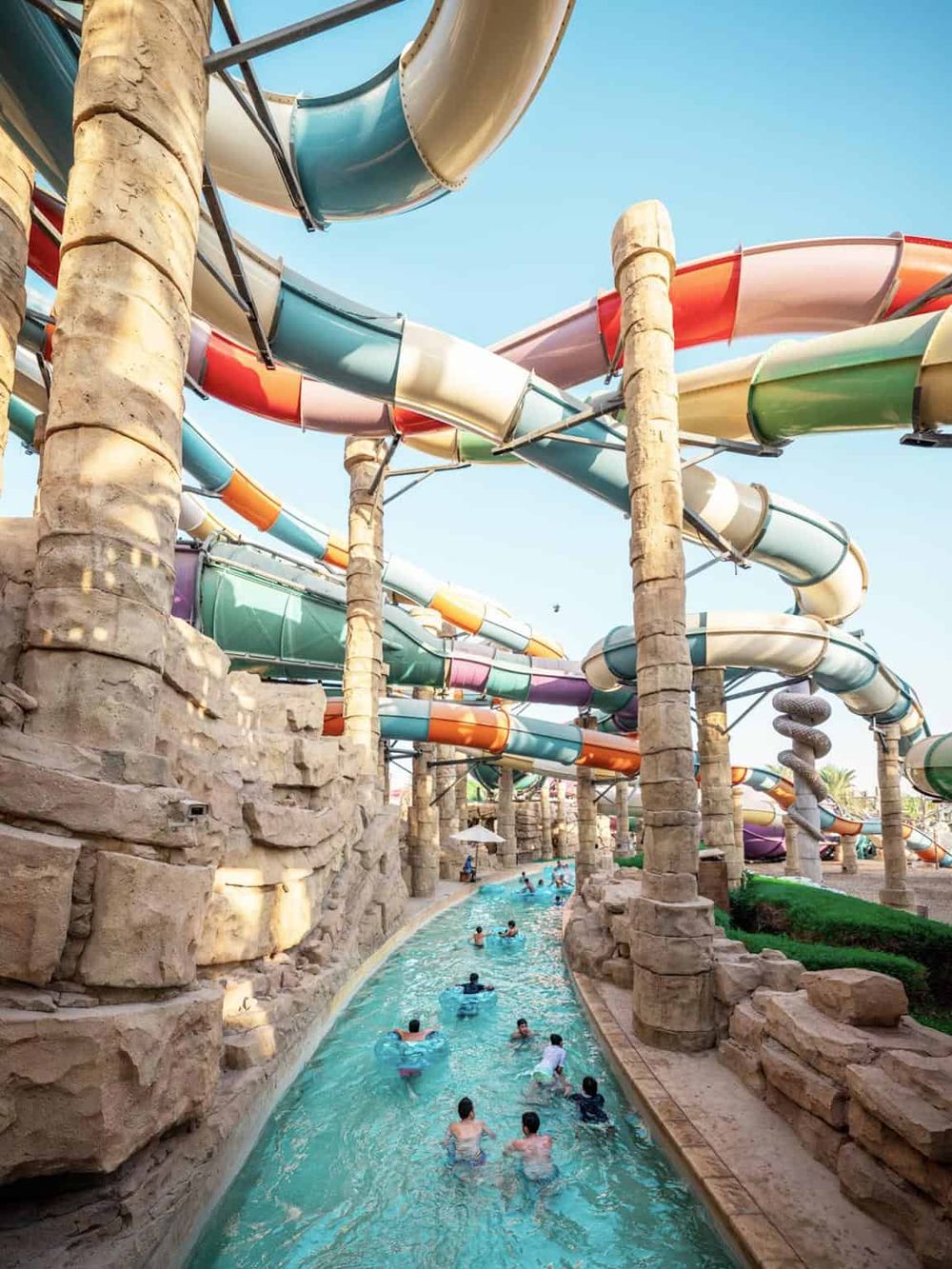 Colorful water slides at a water park with people enjoying the attraction.
