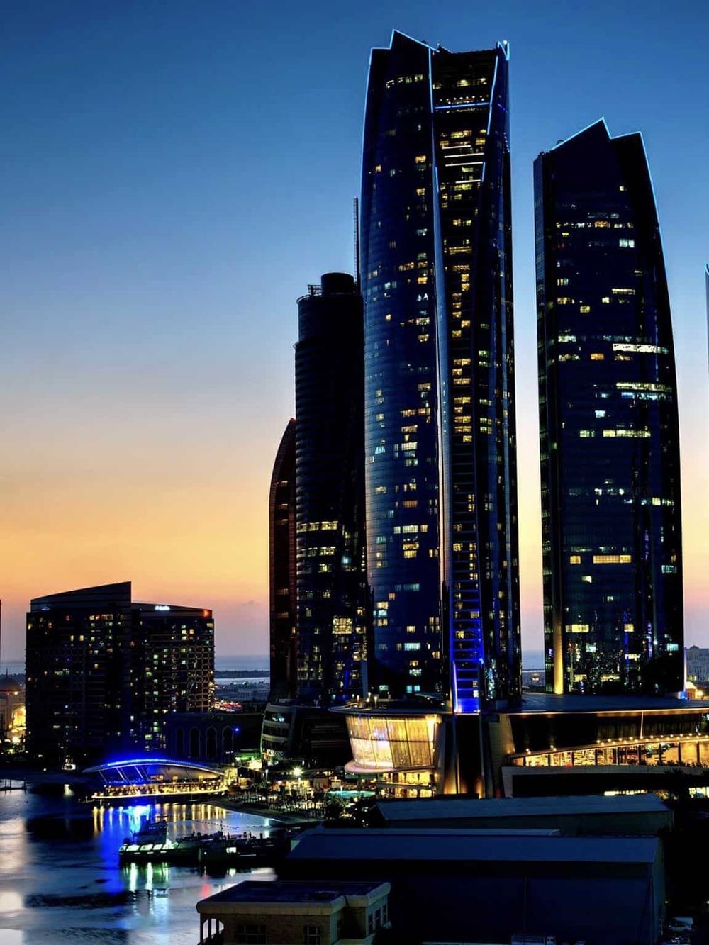 Modern city skyline with illuminated skyscrapers at dusk for seeking directions and urban navigation.
