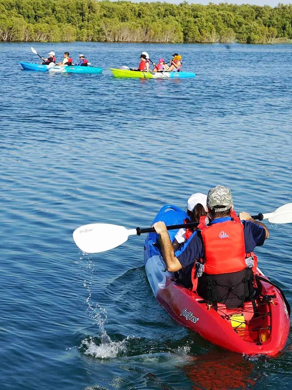 Family kayaking on lake for outdoor adventure and recreation.