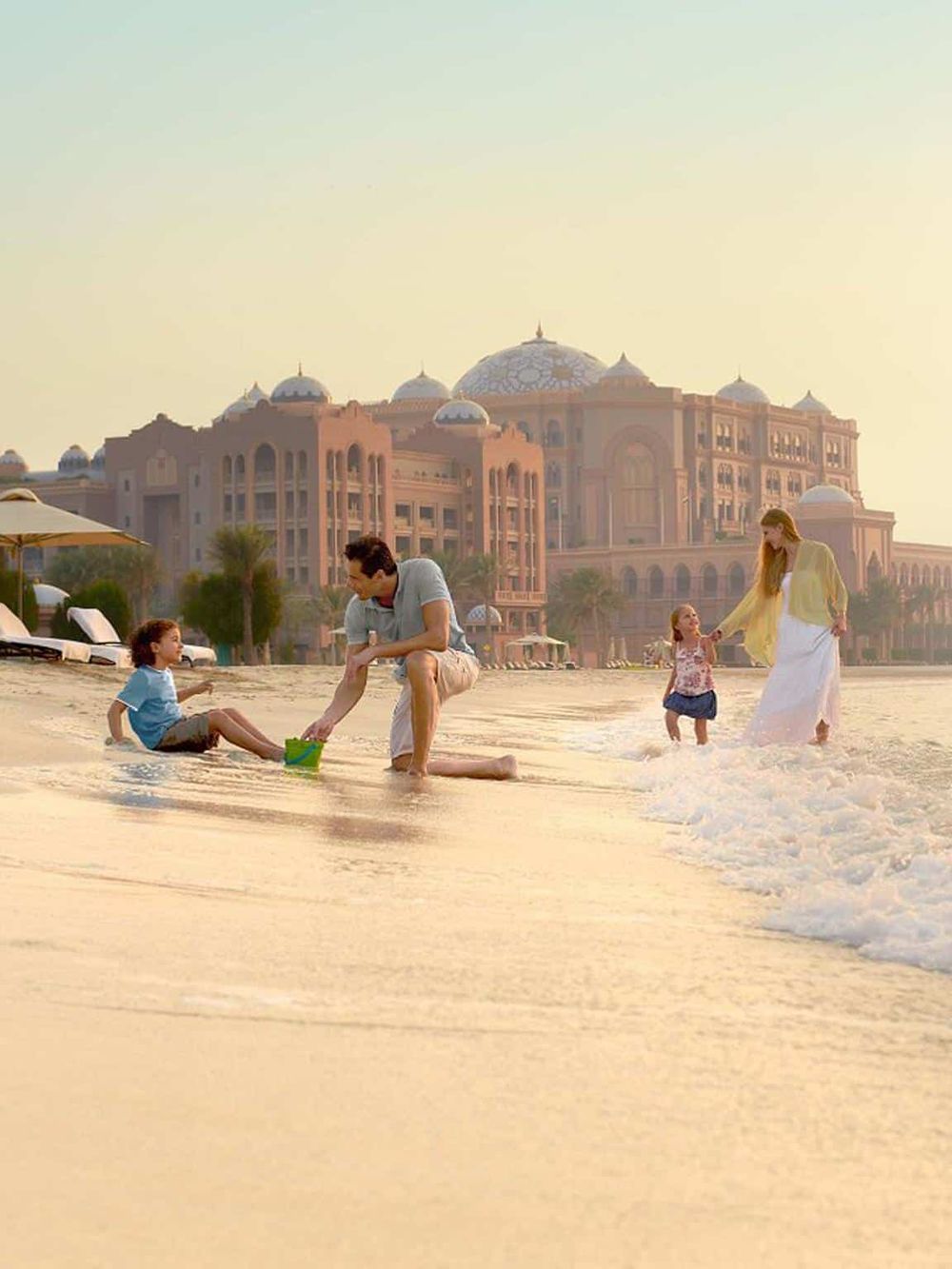 Luxurious hotel resort with family enjoying beach, water activities, and sunset views.