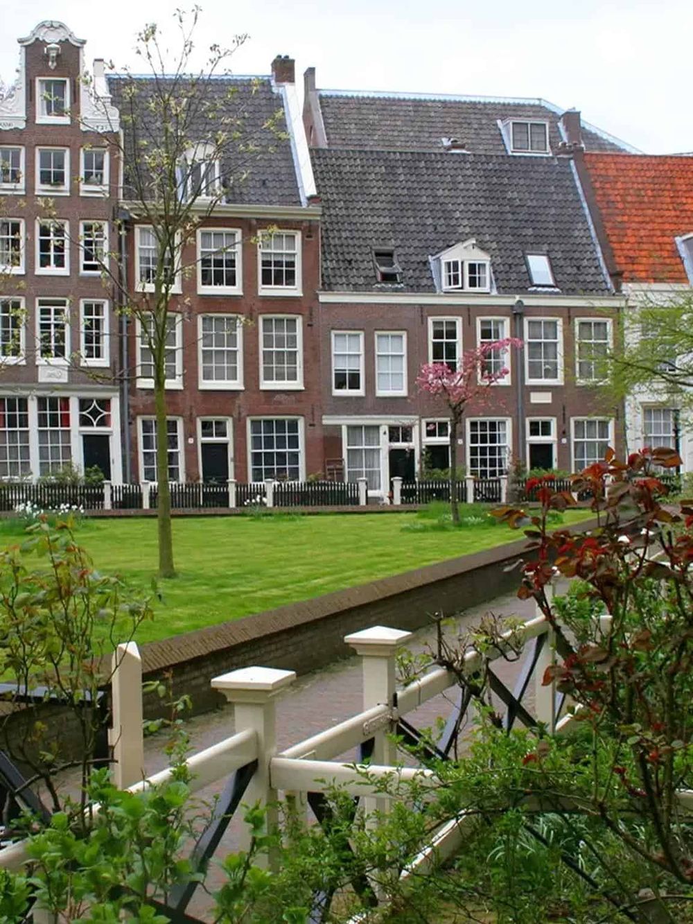 Cozy European-style neighborhood with traditional brick buildings, charming gardens, and lush greenery.
