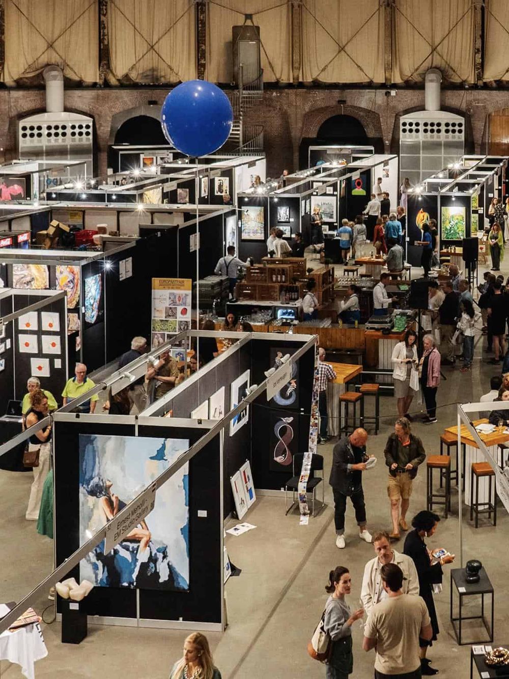 Art exhibition at QuestForDirections art fair, showcasing contemporary artwork and vibrant gallery displays.