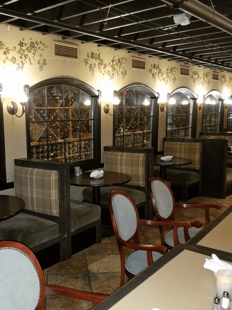 Cozy wine cellar restaurant with wood wine racks and vintage decor.