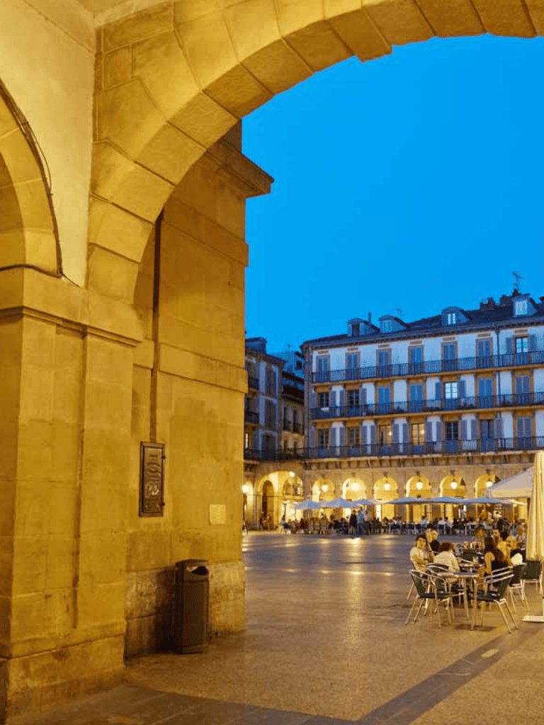 Vibrant city square under evening sky with outdoor dining and historic architecture, perfect for classic European travel destinations.