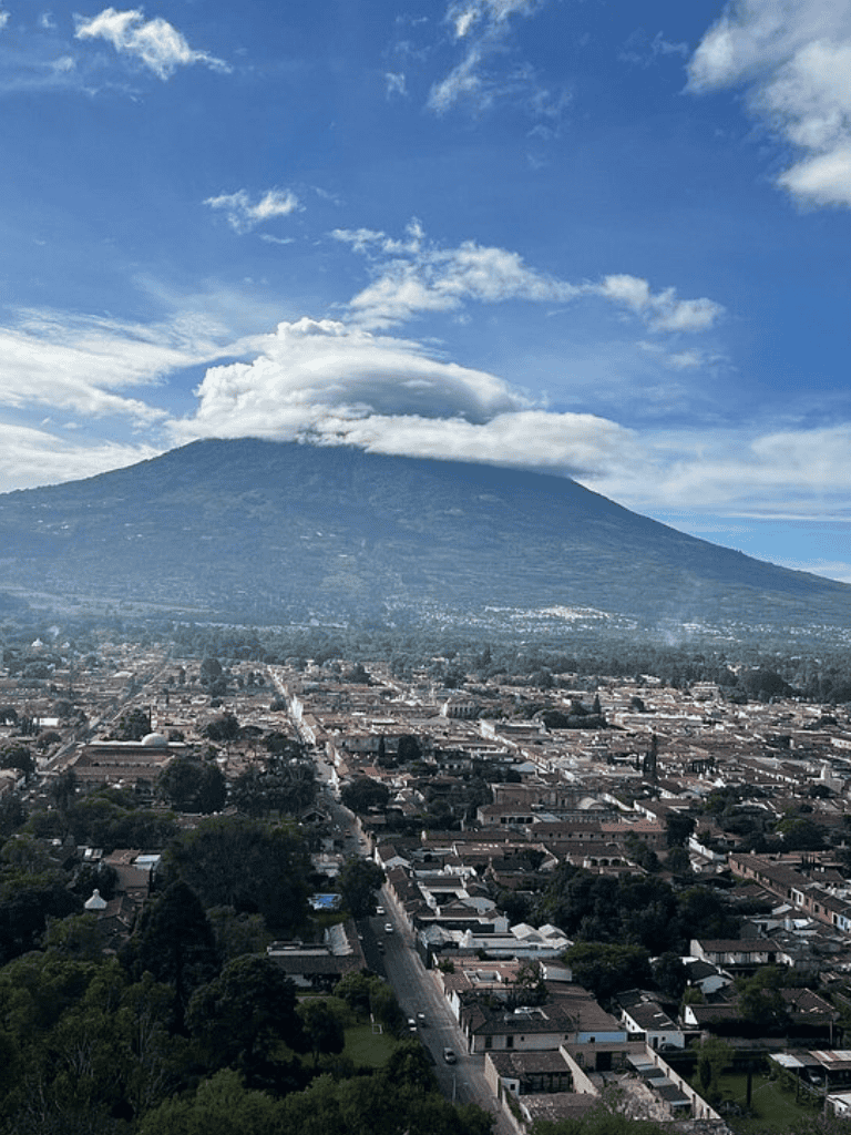Vulcano views over a cityscape with lush greenery and a city street in the foreground, symbolizing travel and exploration.