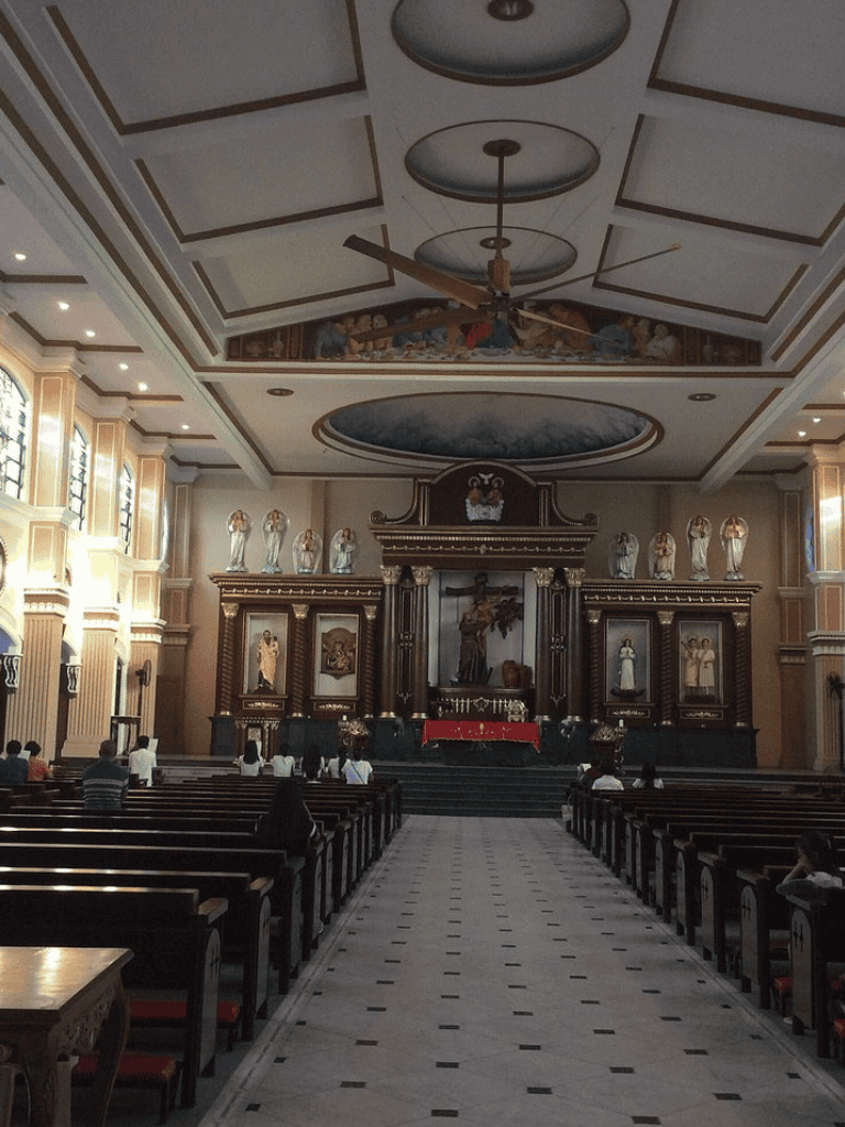 Altar inside a church with religious statues and seating for worshipers, emphasizing spiritual guidance and community prayer.