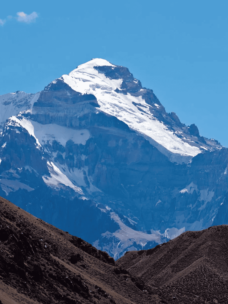 Snow-capped mountain peak with rugged terrain, scenic mountain landscape, and blue sky.