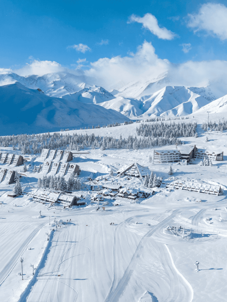 Snowy mountain resort with ski slopes and cozy chalets in a winter landscape.
