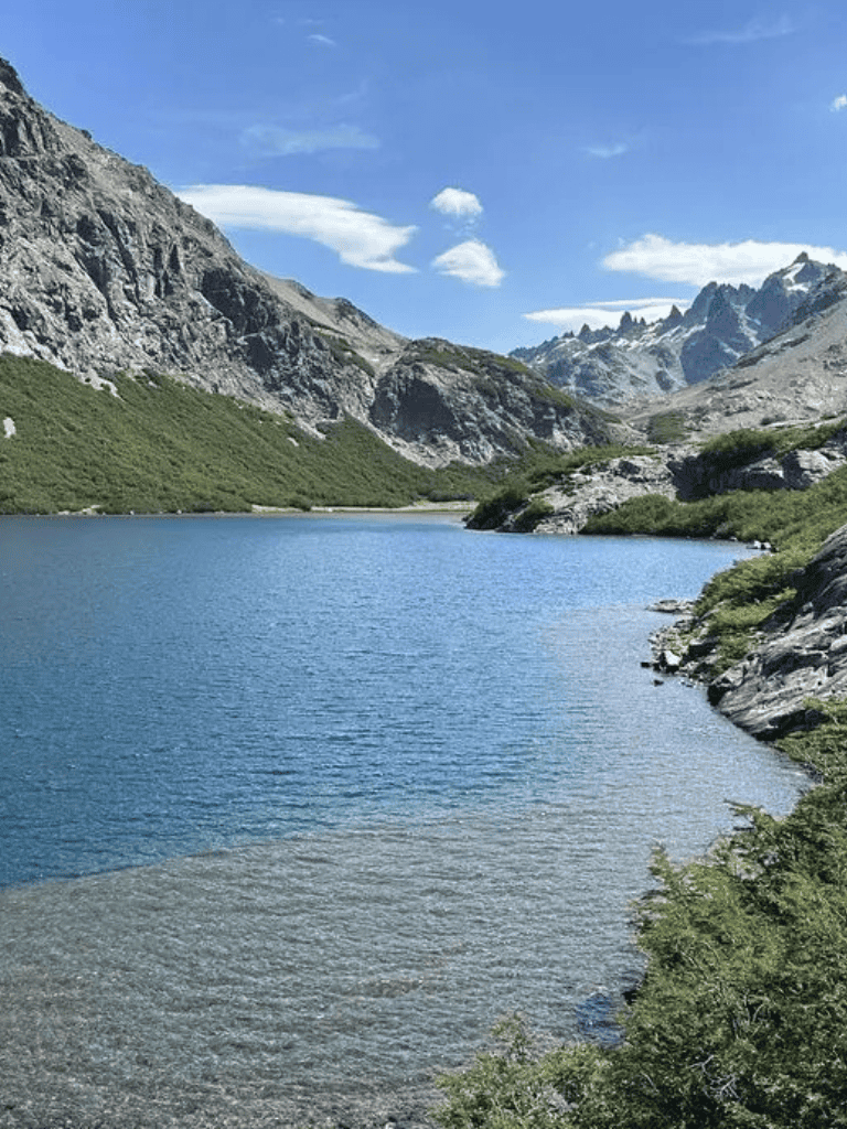 Serene mountain lake surrounded by rugged peaks and lush greenery, perfect for nature adventures and outdoor exploration.