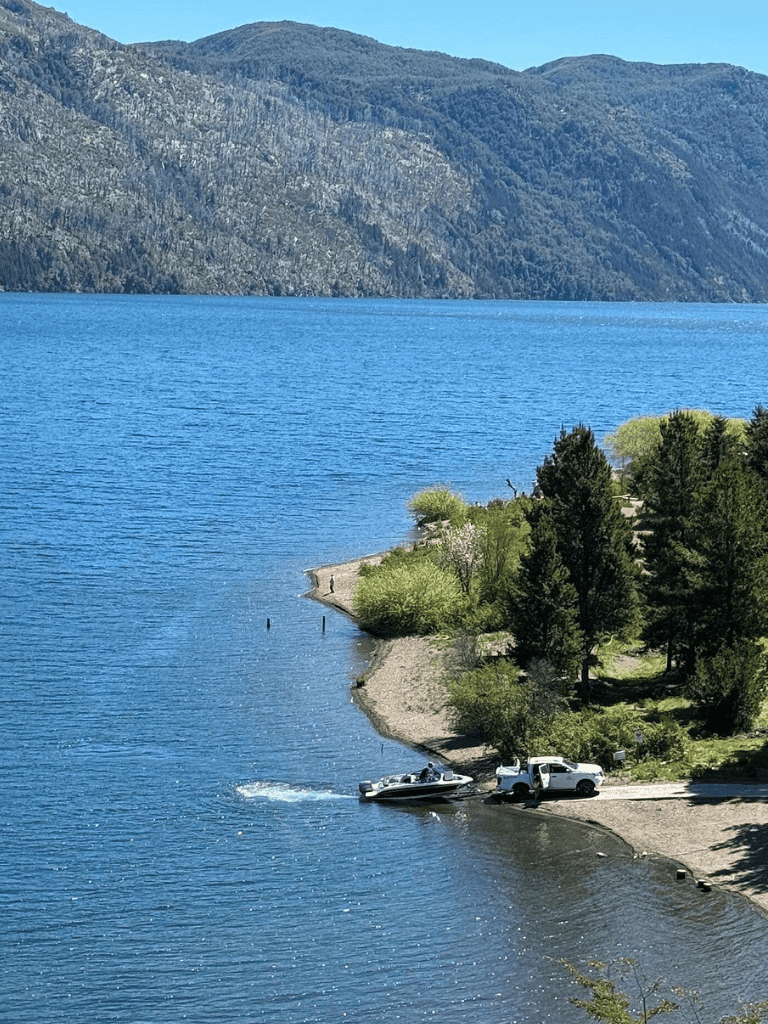 Tranquil lake scenery with mountains, trees, and boat access at QuestForDirections.