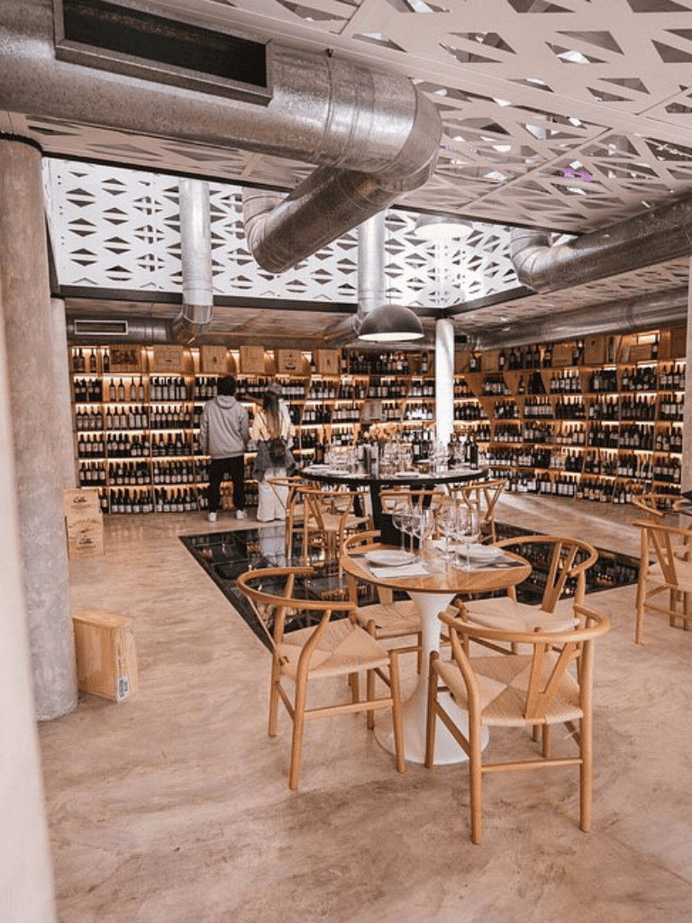 Elegant wine shop and tasting room with modern decor and extensive wine display, perfect for wine lovers.