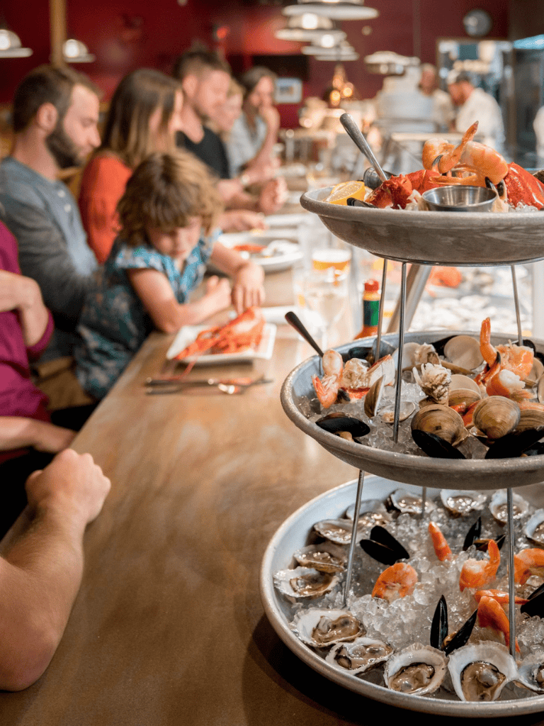 Fresh seafood tower with oysters, shrimp, and clams at a seafood restaurant.