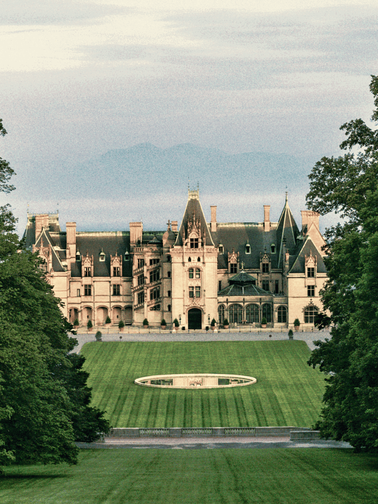 Luxurious castle with sprawling gardens and scenic mountain backdrop.