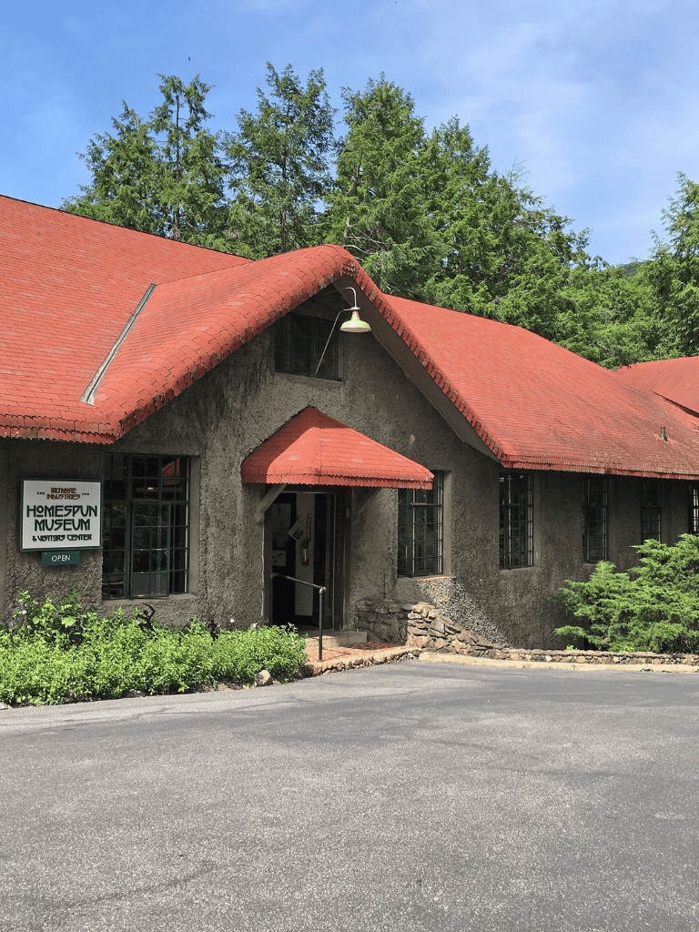 Museum building with red roof and green trees in the background, located at QuestForDirections.