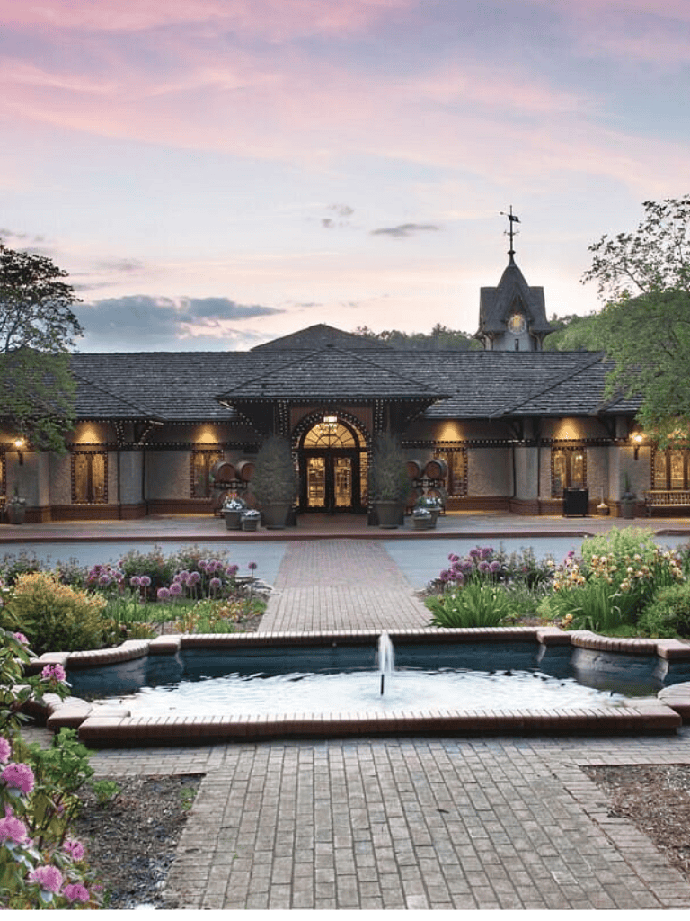 Charming wedding reception venue with elegant architecture and lush garden landscaping.