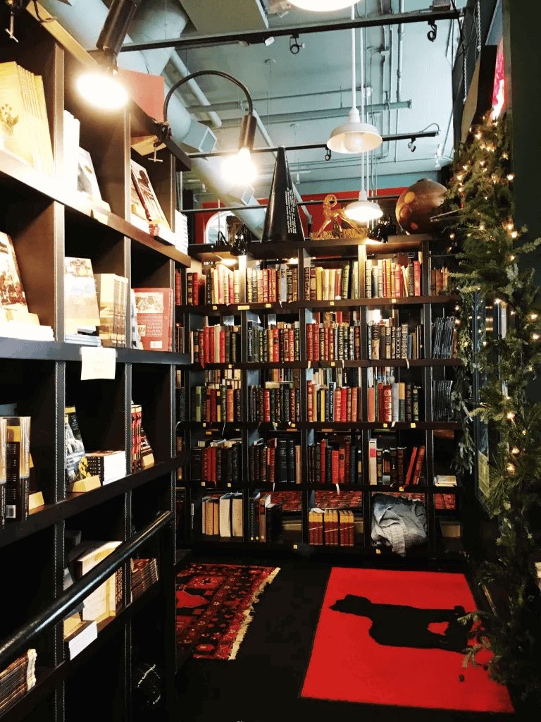 Cozy bookstore with extensive collection of books, festive Christmas decorations, and ambient lighting, ideal for book lovers.