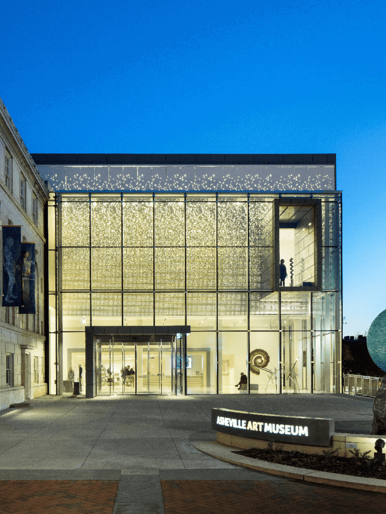 Modern Art Museum in Asheville glowing at night, showcasing contemporary architecture and vibrant art displays.