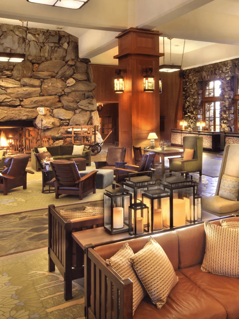 Cozy lodge fireplace with rustic stone chimney and inviting seating area, perfect for relaxing.