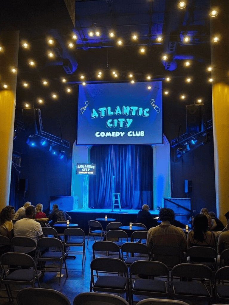 Bright comedy club stage at Atlantic City, with audience seating and vibrant lighting.