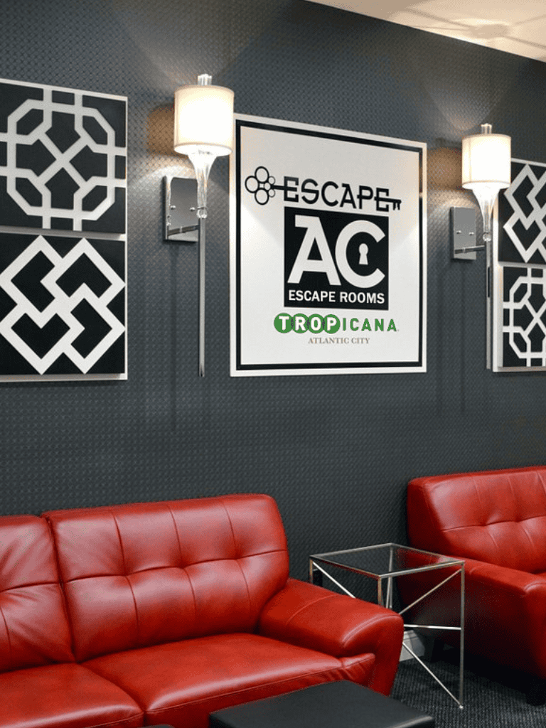 Escape room lounge area with modern decor and red leather sofas.