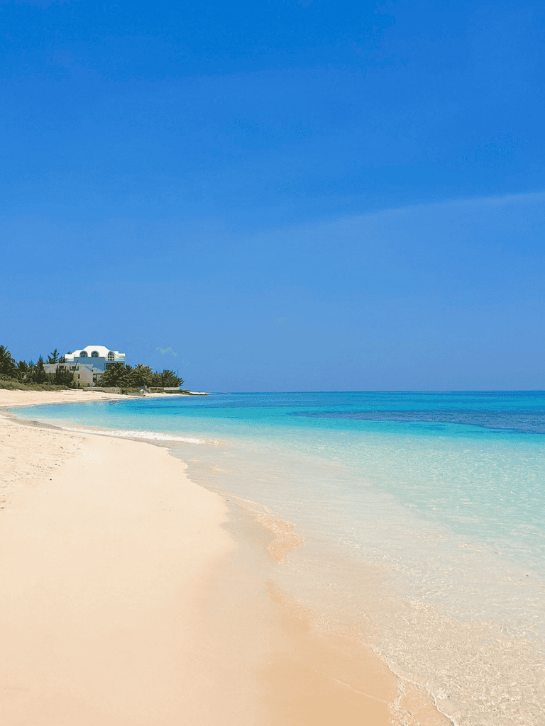 Serene beach with white sand and turquoise waters, perfect for relaxation and vacation.