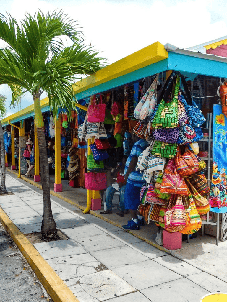 Colorful beach bags and souvenirs at a tropical outdoor market in Cancun, Mexico.
