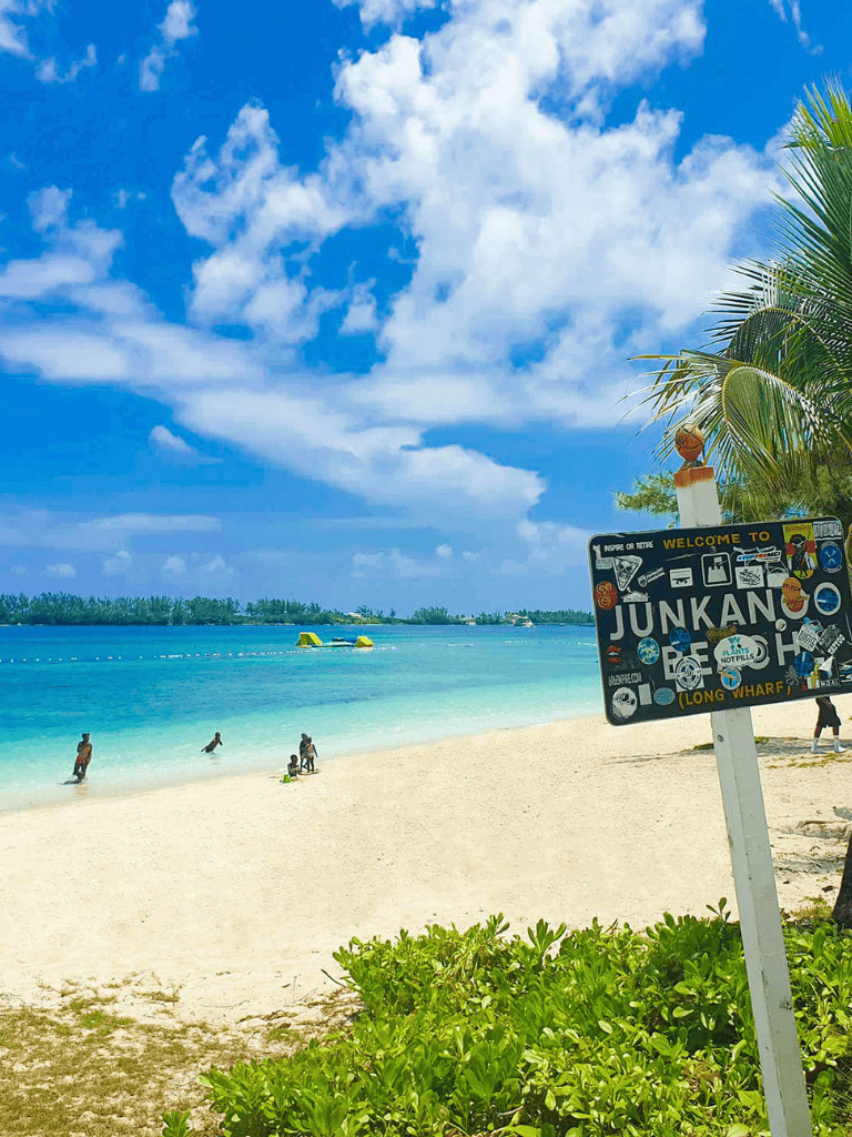 Bright beach scene at Junkanoo Beach, Nassau Bahamas with turquoise waters, blue sky, and palm trees.