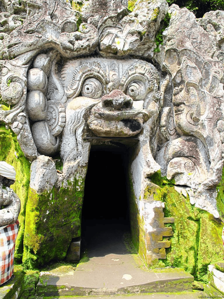 Ancient stone sculpture entrance with intricate carvings and moss decor, located at QuestForDirections.