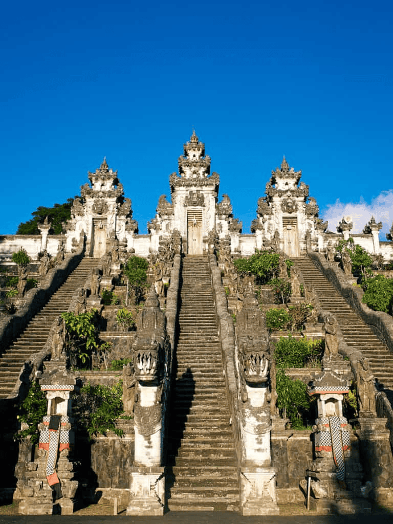Ancient temple staircases with intricate carvings under clear blue sky.