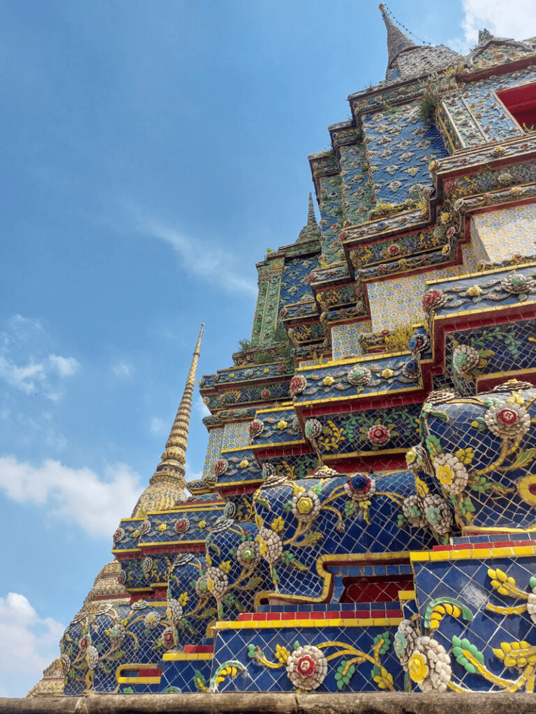 Colorful ornate temple in Bangkok, Thailand, showcasing detailed mosaic artwork and traditional architecture.