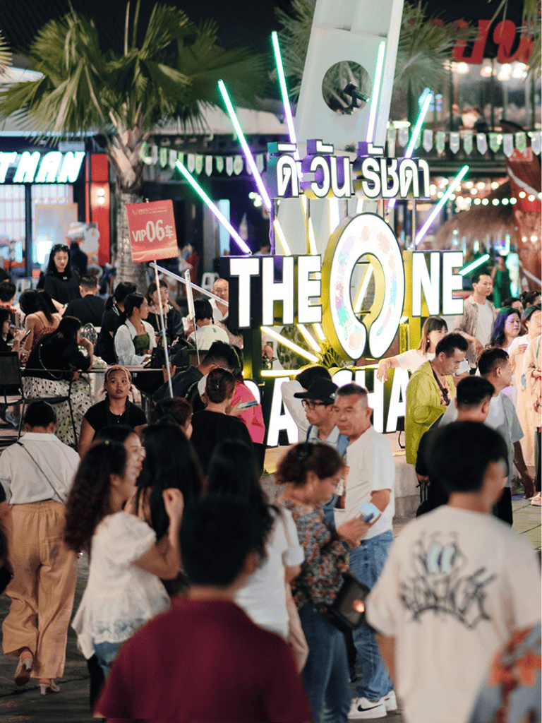 Vibrant night market scene with lively crowd and illuminated "Quest for Directions" sign, showcasing outdoor nightlife and urban entertainment.