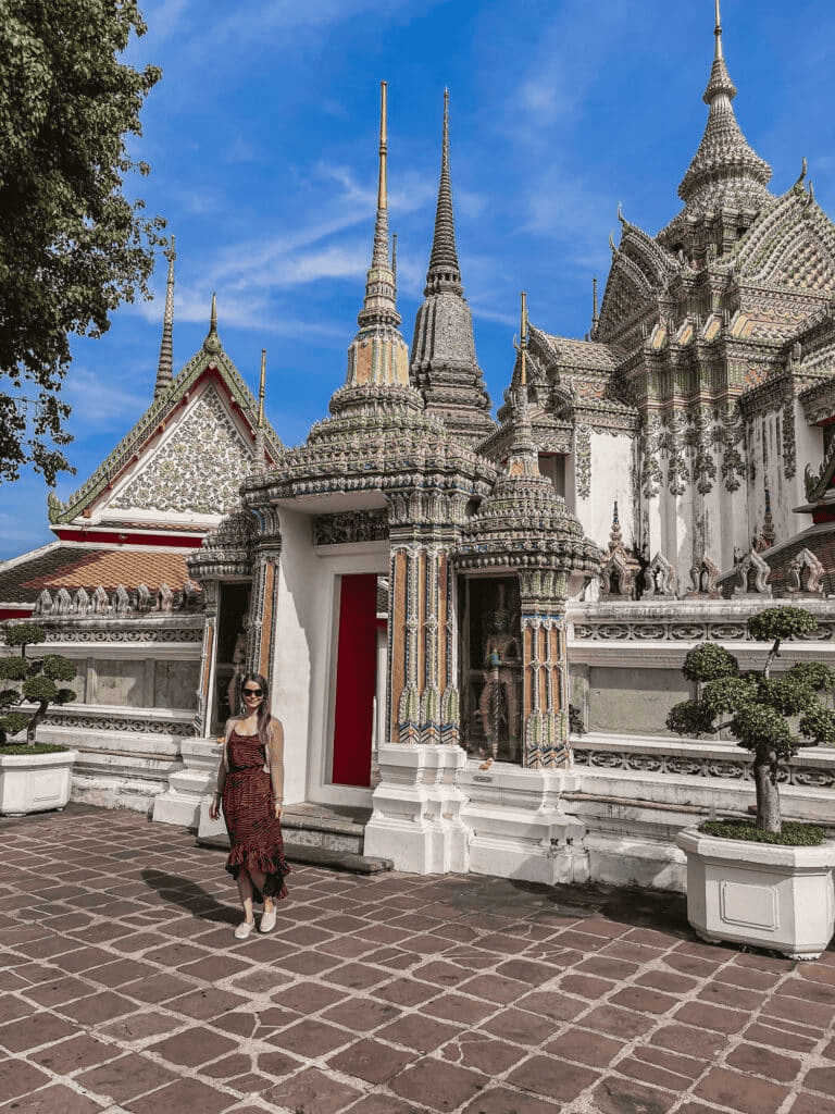 Intricate Thai temple architecture with a woman in front, popular for cultural tours and exploring local traditions.