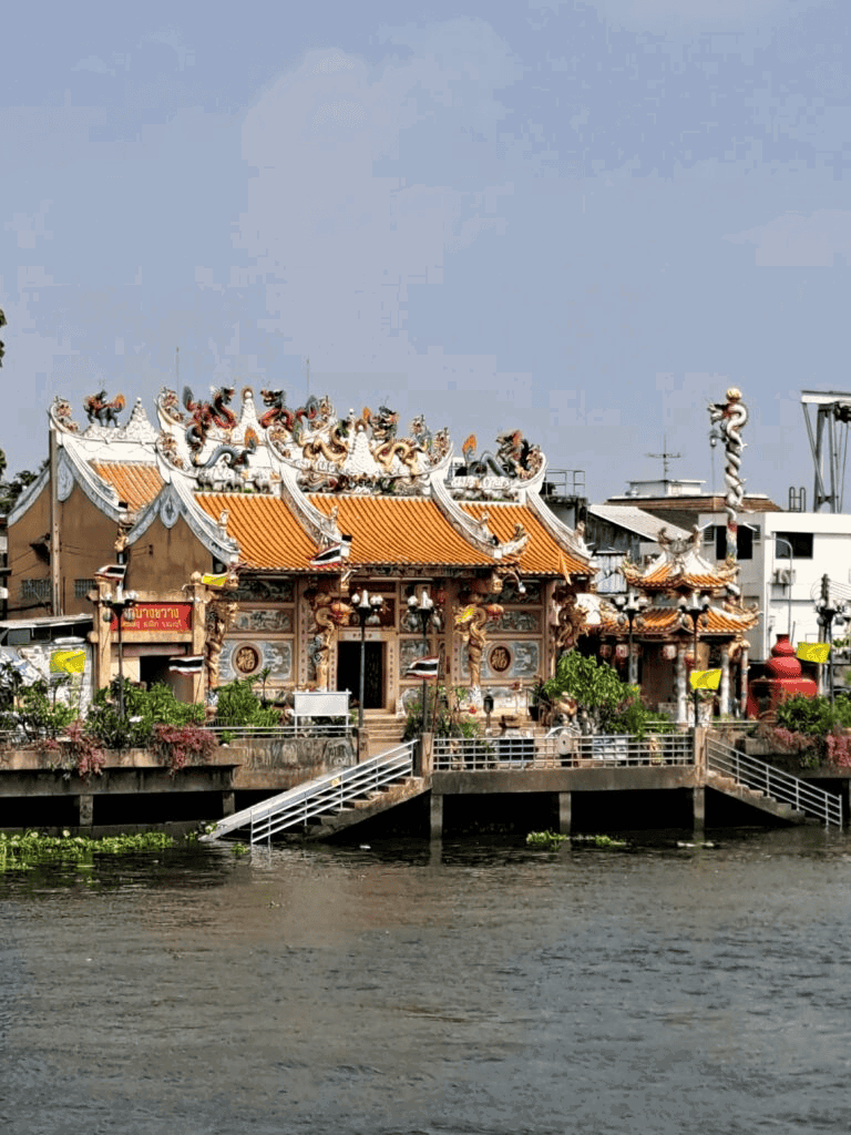 Colorful Chinese temple overlooking water with dragons and traditional architectural details.