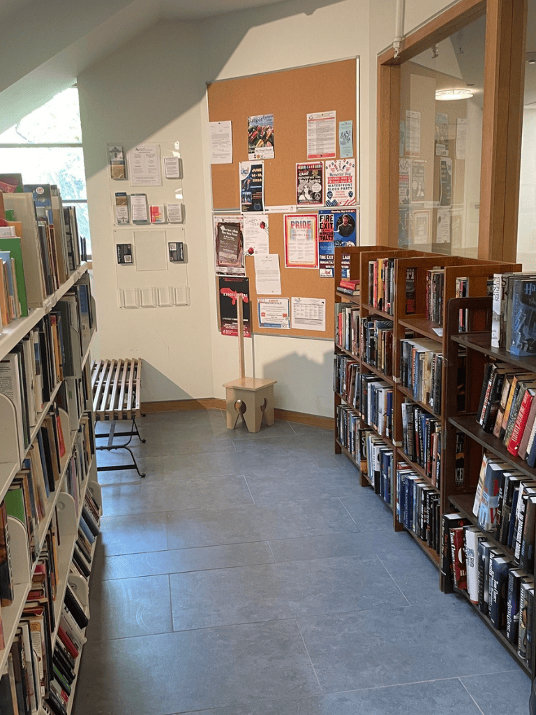 1. Library bookshelves and bulletin board in a community center interior.