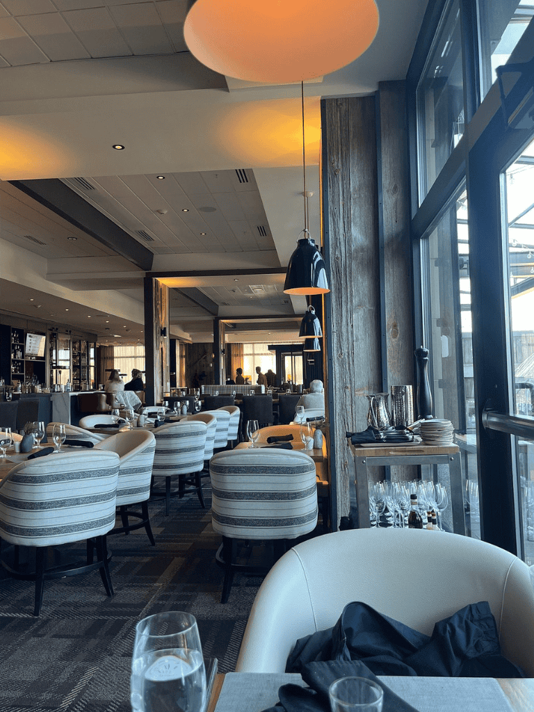 Elegant restaurant interior at QuestForDirections, showcasing modern decor and large windows with natural light.