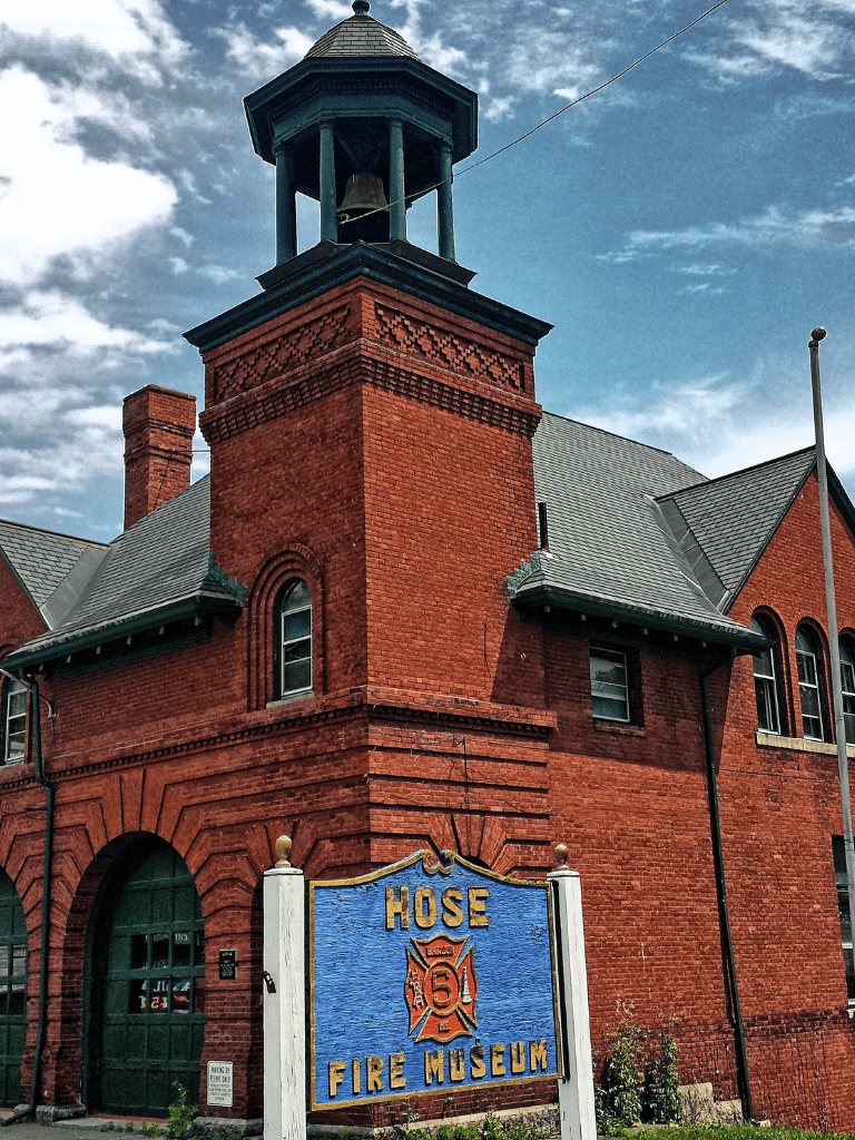 Historic red brick fire station with a sign for Hose Fire Museum.