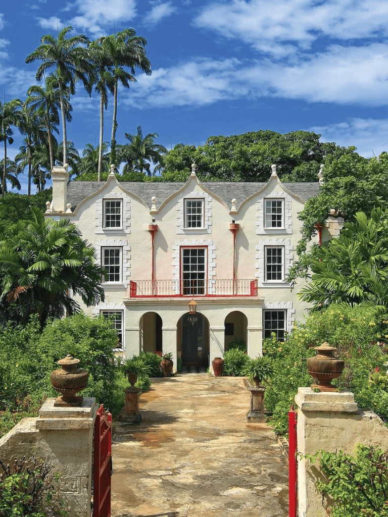 Elegant historic house surrounded by lush tropical gardens, ideal for travel destinations and architecture enthusiasts.