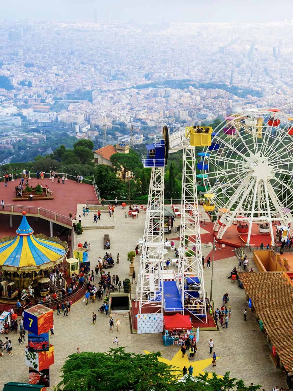 Bright amusement park Ferris wheel with city views at Mount Montjuïc, Barcelona, offering fun and scenic shortcuts for visitors.