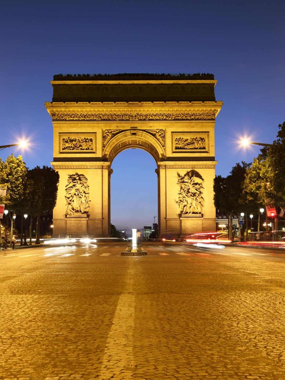 Golden Arc de Triomphe illuminated at twilight in Paris, iconic landmark, popular tourist destination, visit for history and architecture.
