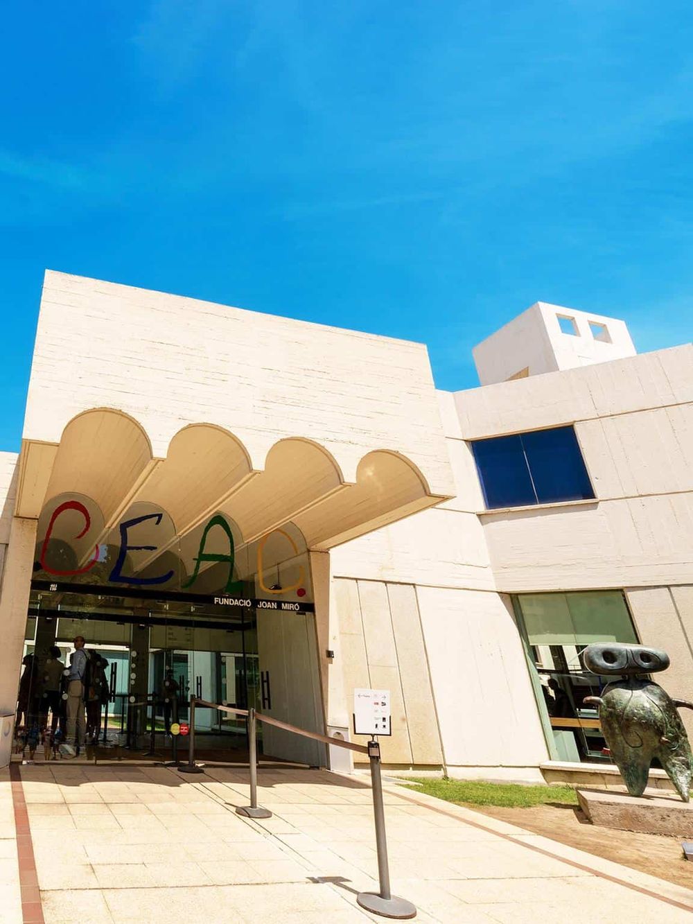 Modern architecture of the Joan Miró Foundation, a famous art museum in Barcelona, under a clear blue sky.