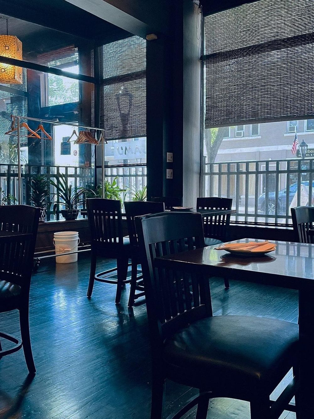 Cozy restaurant interior with large windows, black chairs, and a modern ambiance.