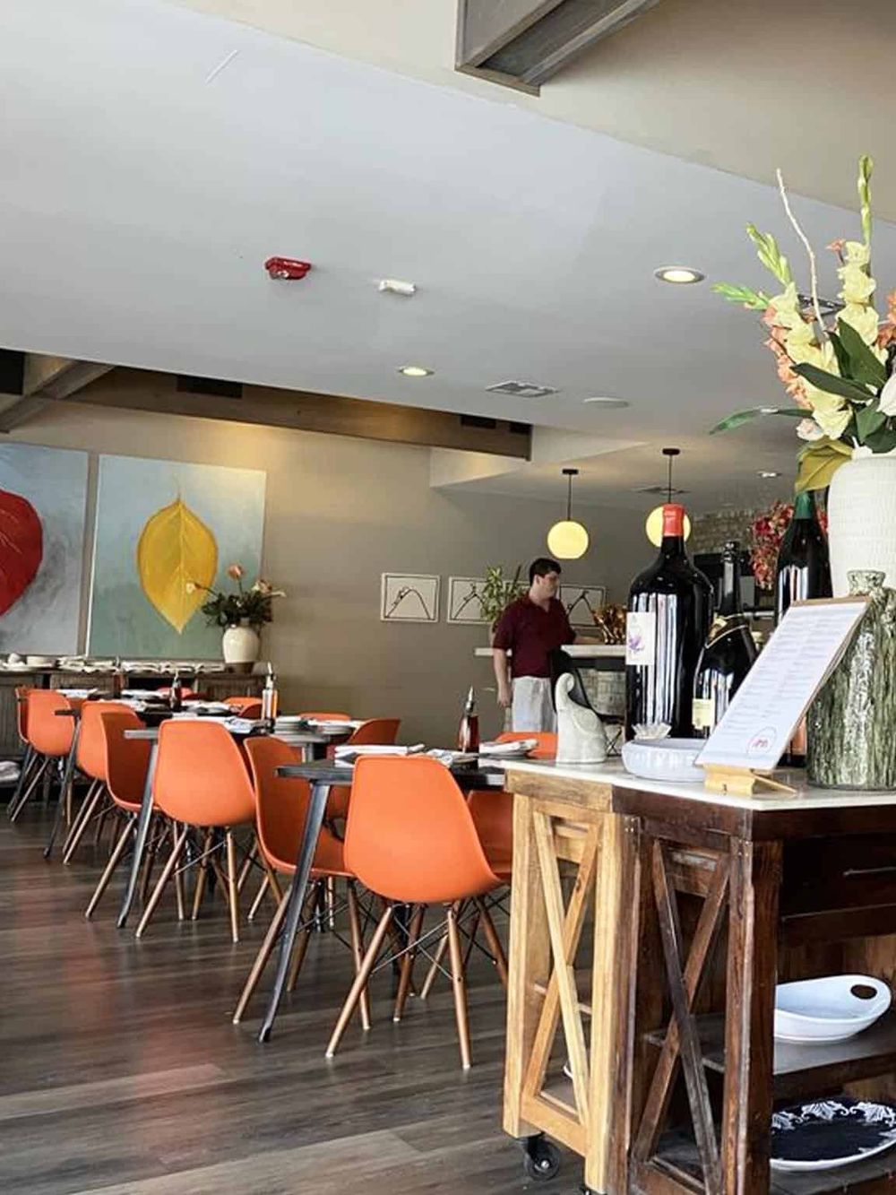 Modern restaurant interior with orange chairs and contemporary decor, perfect for dining and socializing.