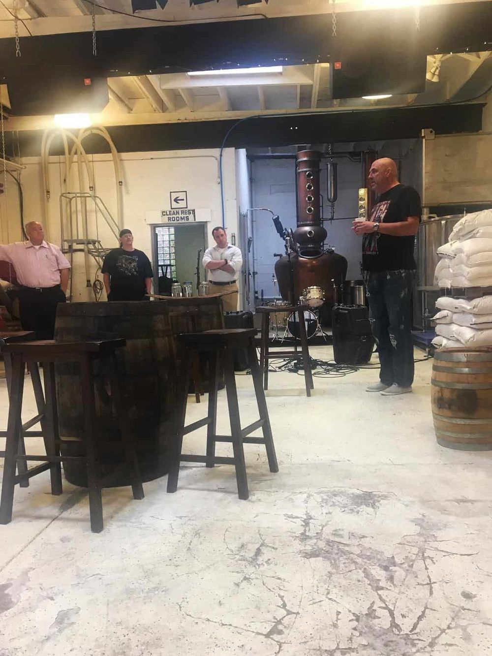Whiskey distillery tour with a master distiller explaining the process to visitors in an industrial setting.